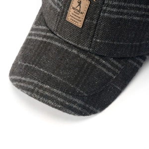 Dettaglio cappello in lana grigio scuro con toppa in pelle marrone di qualità