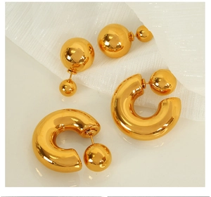 Macro detail of high-polish gold titanium steel double ball earrings and C-shaped studs