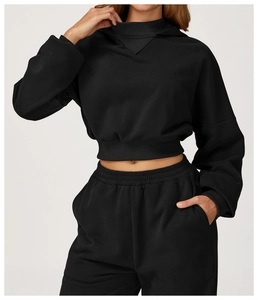 Detail view of black cropped hoodie and joggers set with thick knit fabric texture