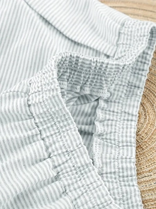 Macro detail of elastic waistband and grey seersucker fabric texture on loungewear shorts