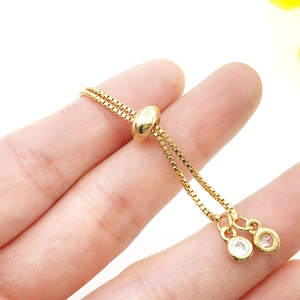Detailed close-up of a gold adjustable bracelet with sliding clasp and round zircons
