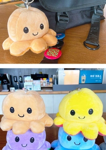 Detail of colorful reversible octopus plush keychain with cute embroidered smile on a backpack