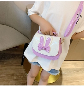Close-up of cute rabbit ears and purple bow detail on a girl's crossbody bag