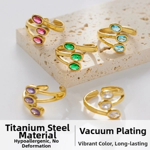 Detailed close-up of triple-layered gold stainless steel rings with oval colored zircon stones