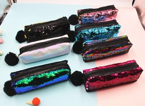 Detail of reversible sequin pencil cases with fluffy pompom zipper in seven various colors