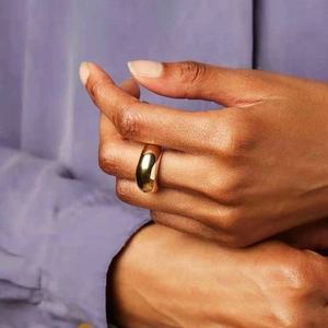 Französischer Vintage Goldring mit gewölbtem Design am Finger vor lila Hemd