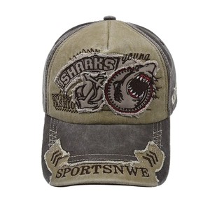 Detail of vintage shark embroidery and distressed patches on military green baseball cap