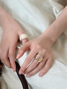 Detail of resin oval rings in marble texture and gold foil styles on a model finger