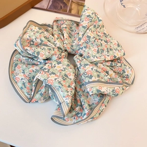 Vue détaillée du chouchou floral avec bords en dentelle et bordure en tricot élastique