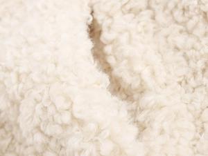 Macro shot of high-quality cream white faux fur fabric texture for warm winter coats