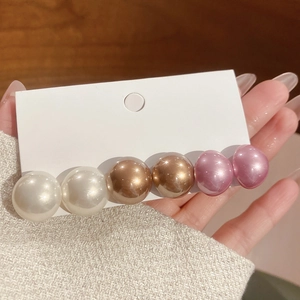 Detail of elegant gradient pearl hair clip with six resin beads on a display card
