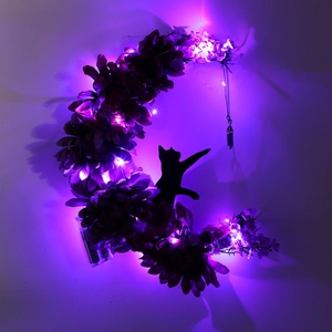Detail of moon cat wreath with purple LED lights, black roses and crystal pendant decor