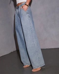 Detail showing the drape and flow of light blue high-waist wide-leg denim jeans