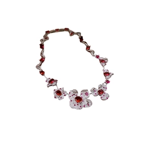 Parure de bijoux fleurie avec pierres rouges et zircons sur collier en argent