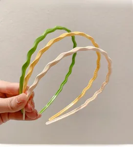 Macro detail of three wavy matte headbands in green, yellow and milky white set