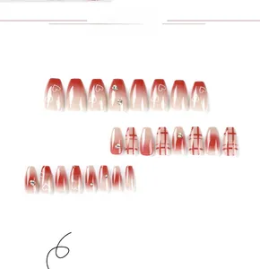 Detail of red gradient press-on nails with white hearts, plaid patterns, and rhinestones