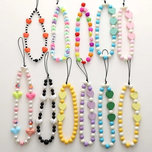 Detail of ten handmade beaded phone charms with heart shapes and colorful acrylic beads
