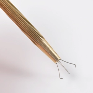 Macro detail of gold anti-slip handle and four-claw mechanism for piercing tools