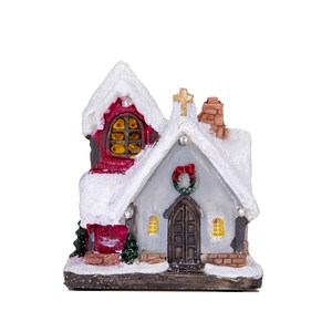 Detail of miniature light-up Christmas church with snow roof and LED glowing windows