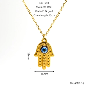 Macro shot of Hamsa hand and blue Evil Eye pendant on an 18K gold-plated necklace