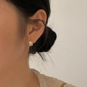 Detail of triple-layer silver hoop earrings with sparkling pavé cubic zirconia