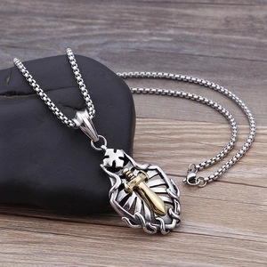 Detailed macro shot of a two-tone sword and cross shield pendant on a box chain
