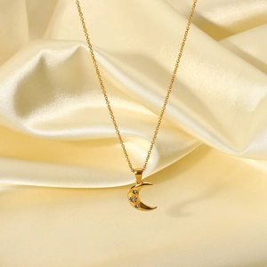 Macro detail of 18K gold plated crescent moon pendant featuring three sparkling zircons