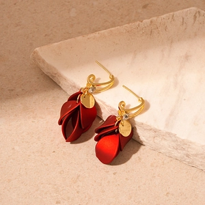 Detailed view of matte red petal earrings with sparkling rhinestone and golden needles