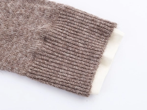 Detailed macro view of the brown ribbed knit sweater cuff with white lining detail