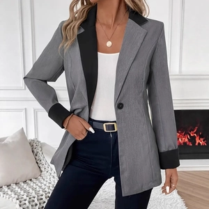 Détail du blazer gris cintré avec revers noirs contrastés et poignets repliés sur mannequin