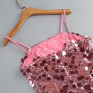 Detail of pink sequin dress featuring rhinestone straps and large reflective sequins