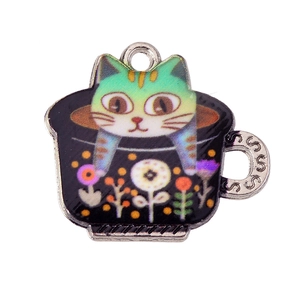 Detailed view of a cute cartoon cat pendant inside a black metal tea cup charm
