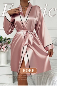 Detail of dusty rose satin robe featuring elegant black piping and silky texture