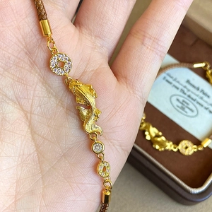 Detailed view of gold plated koi carp bracelet with zircon beads and braided rope