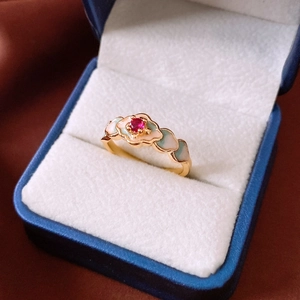 Detail of 18K gold plated vintage ring with red gemstone and enamel floral design