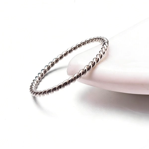 Minimalist twisted rope silver ring with metallic spiral texture on white base