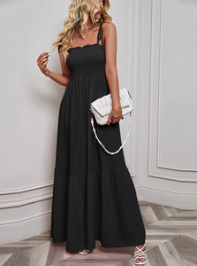 Detail of black summer maxi dress featuring a smocked elastic bodice and ruffled hemline