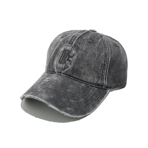 Detail of washed denim baseball cap with distressed brim and embroidered C letter patch