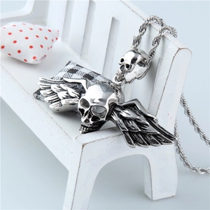 Vue détaillée du pendentif ailes d'ange et crâne argenté sur un mini banc blanc élégant