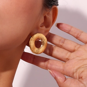 Retro 18K gold plated stainless steel hollow geometric hoop earrings worn by a model