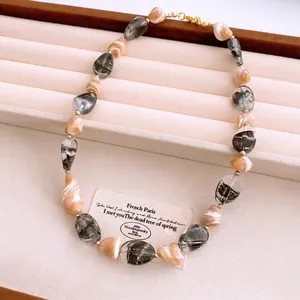 Collier de perles irrégulières avec intercalaires dorés sur un plateau en velours