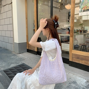 Detail of purple checkered canvas tote bag with bubble texture shown in street style