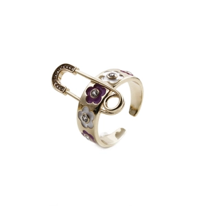 Gros plan détaillé d'une bague trombone dorée avec des fleurs de marguerite en émail coloré