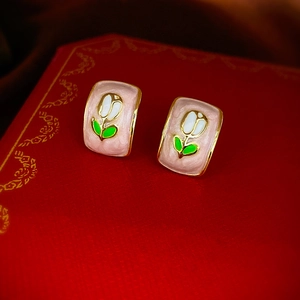 Macro view of vintage rectangular pink tulip enamel stud earrings with gold plating