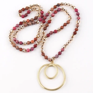 Detail of beaded necklace with semi-precious stones and golden double circle pendant