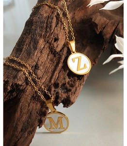 Detailansicht der goldenen M und Z Buchstaben-Perlmuttanhänger an feinen Ketten