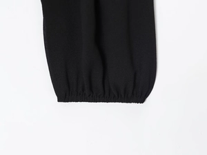 Detailaufnahme des schwarzen Georgette-Hemdärmels mit elastischem Bündchen und Textur
