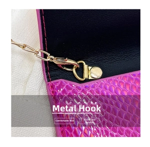 Dettaglio della pochette rosso rosa effetto serpente con gancio dorato e fodera nera