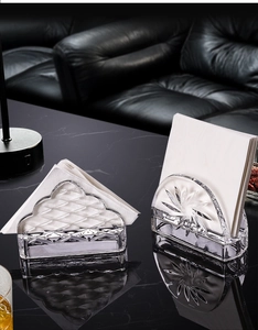 Detail of luxury crystal glass napkin holders with starburst and wave textures on marble
