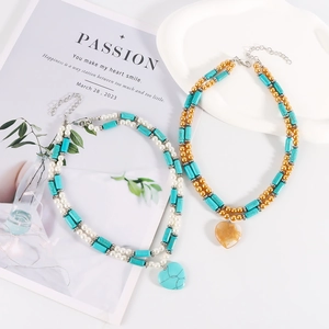 Detail of double-layer beaded necklace featuring turquoise beads and a heart stone pendant